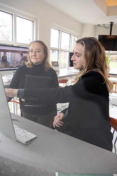 a student points at a screen while a career counselor listens